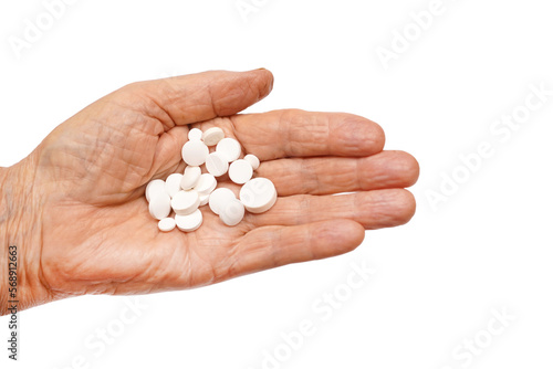a handful of white pills in the hand of an elderly man. medicines for chronic diseases