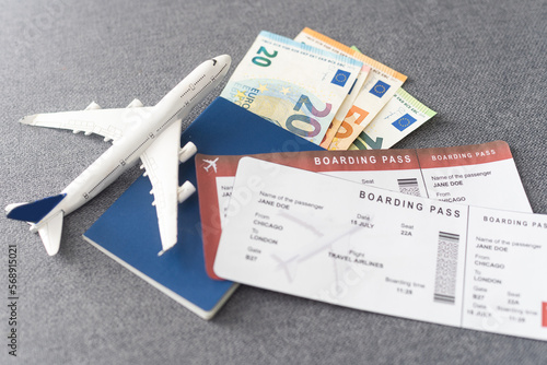 Passports, boarding passes and toy airplane on gray table