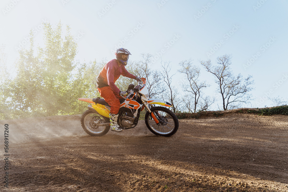 Obraz premium Man riding motorbike on motocross track.Extreme and Adrenaline. Motocross rider in action. Motocross sport. Active lifestyle