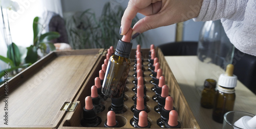 Tableau sur toile woman's hand arranges bach flower remedies in wooden box