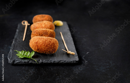 Serving of gourmet style ham croquettes with a black background. photo