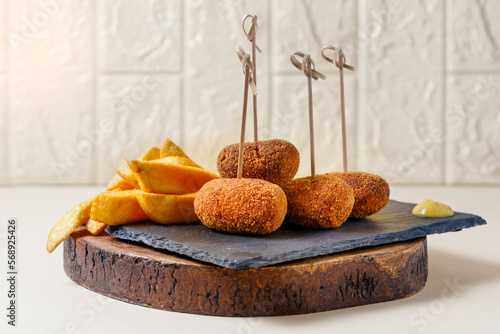 Snack of ham croquettes and chips photo