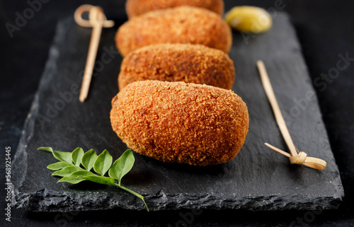 Close-up of gourmet-style ham croquettes with a black background. photo