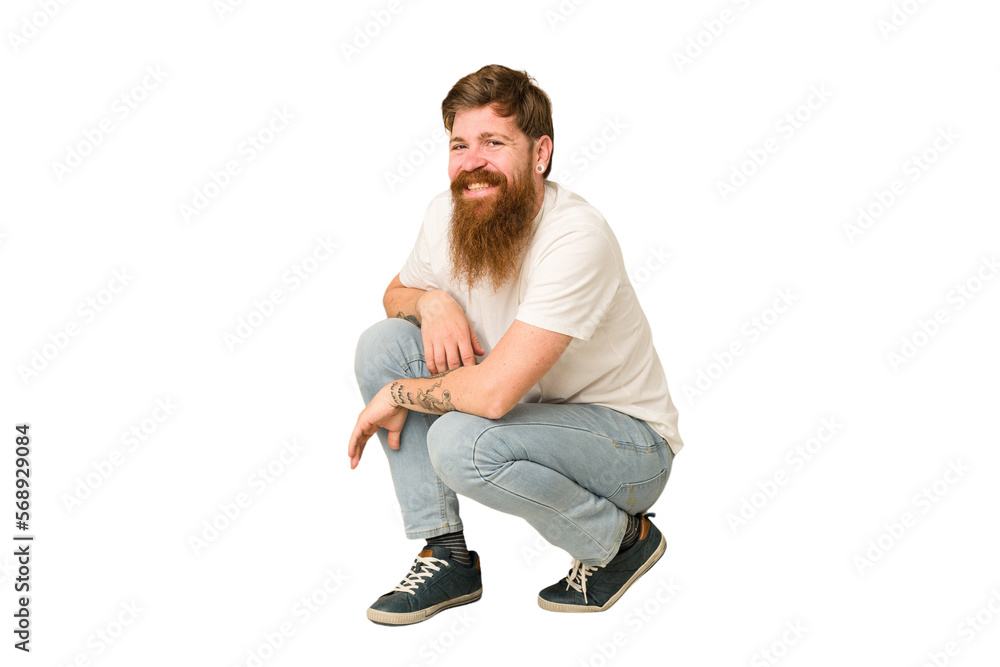 Adult redhead man sitting on the floor isolated Adult redhead man sitting on the floor isolated