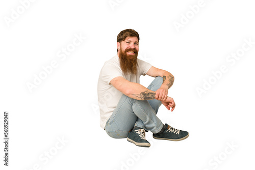 Adult redhead man sitting on the floor isolated