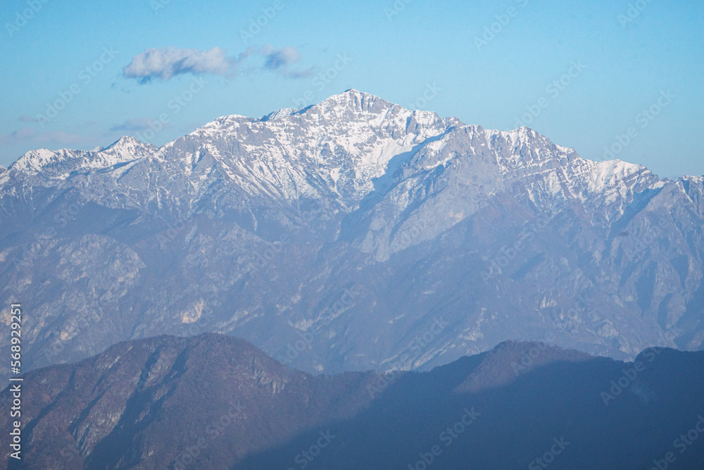 The alps of lake Como and lake lugano seen from val d'Intelvi during a sunny winter afternoon, near the village of Casasco d'Intelvi, Italy - February 2023.