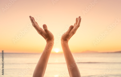Woman hands up to the sunlight at dawn feeling grateful. Freedom and spirituality concept.