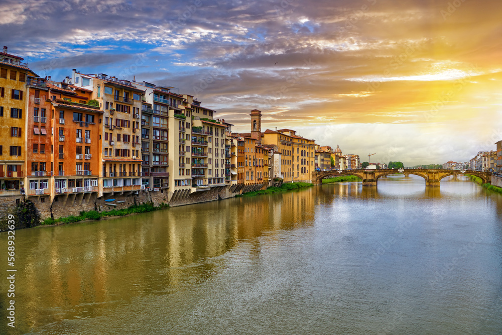 Scenic sunset cityscape over Arno River, St Trinity Bridge and colorful old houses along the river in Florence city