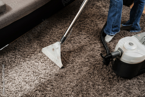 Line on carpet after spraying water of dry cleaning extractor mop machine close-up. Domestic cleaning service cleaner is removing dirt and dust from carpet using mop dry cleaning extraction machine. photo