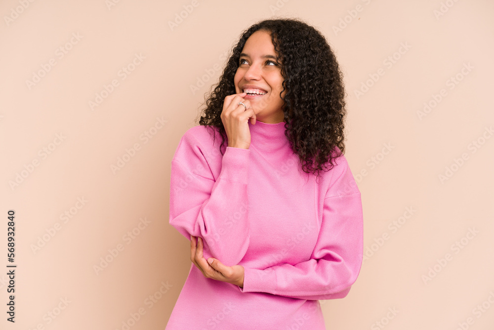 Young african american curly woman isolated relaxed thinking about something looking at a copy space. Young african american curly woman isolated relaxed thinking about something looking at a copy space.