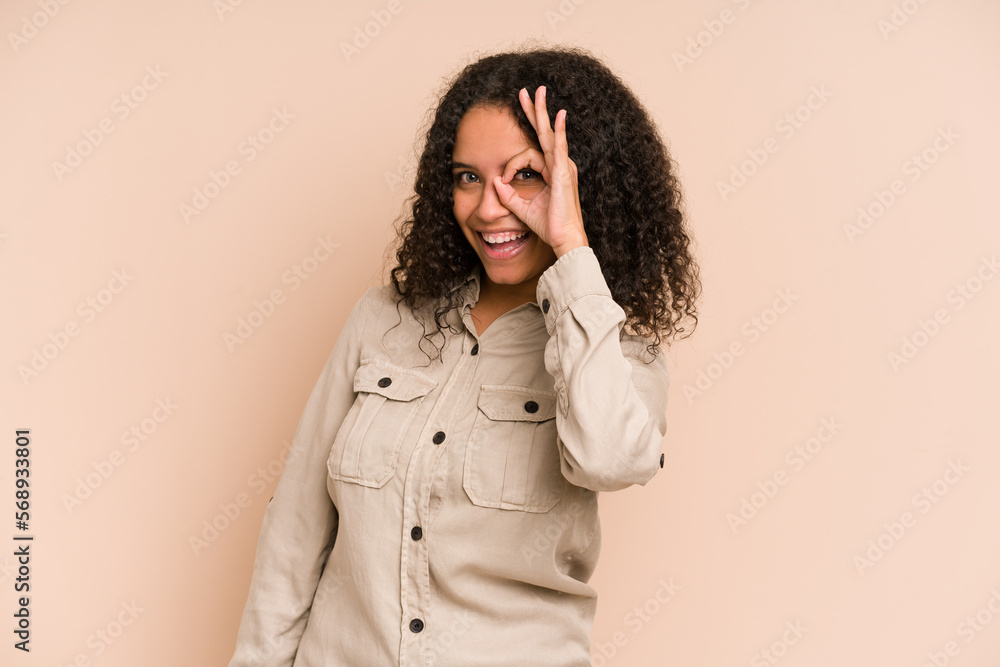 Young african american curly woman isolated excited keeping ok gesture on eye. Young african american curly woman isolated excited keeping ok gesture on eye.