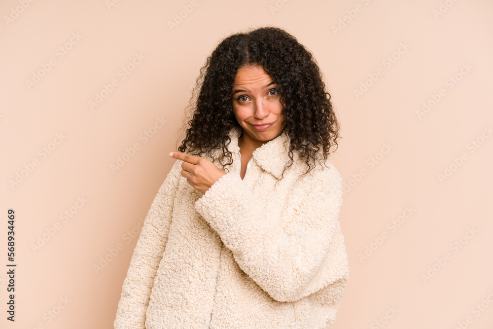 Young african american curly woman isolated smiling and pointing aside, showing something at blank space. Young african american curly woman isolated smiling and pointing aside, showing something at blank space.