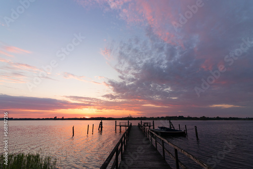 Wooden jetty at the Schlei fjord in Sieseby with epic sunset sky.