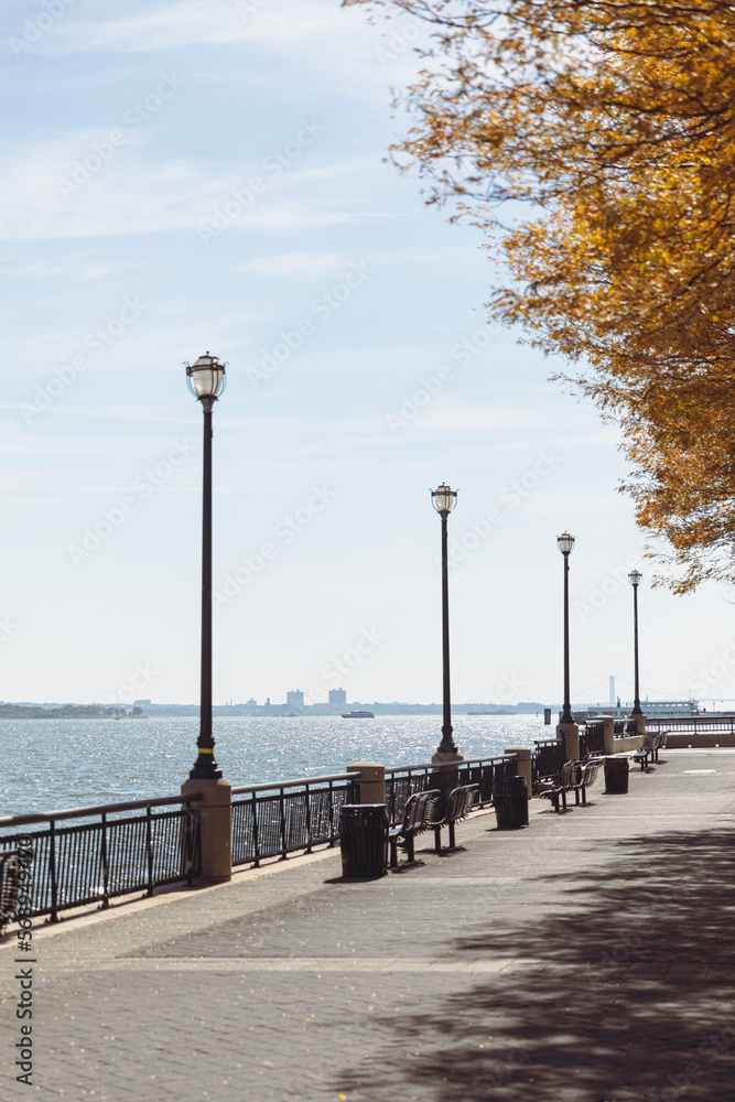 embankment with lanterns and walkway near river bay in New York City.