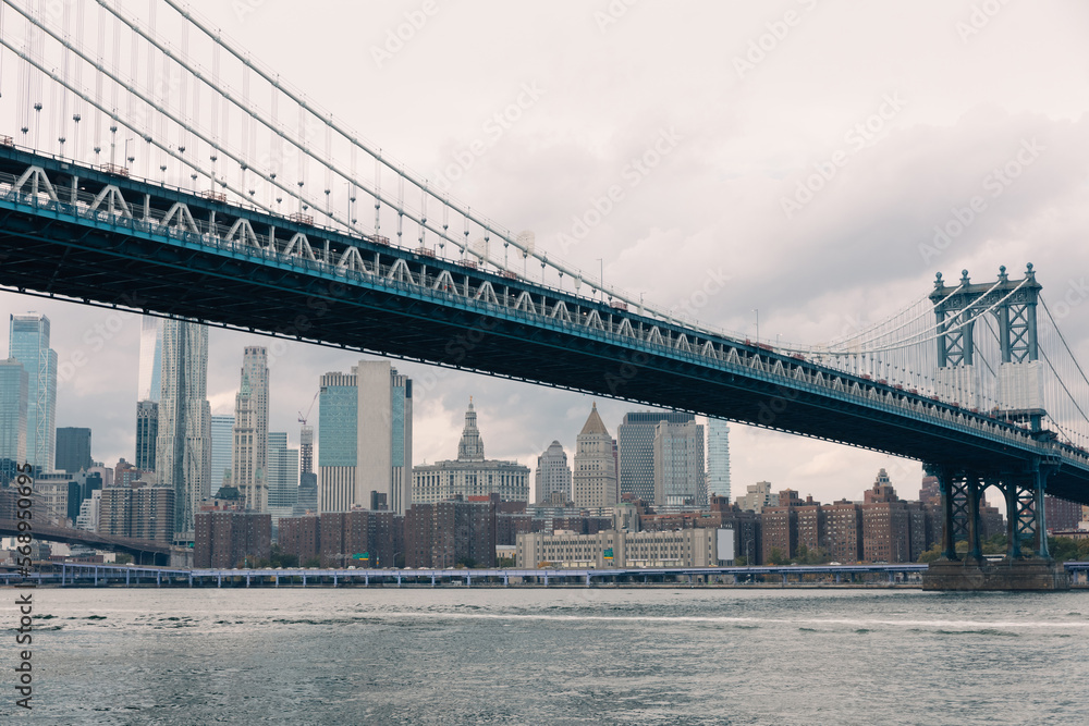 modern skyscrapers and Manhattan bridge above Hudson river in New York City.