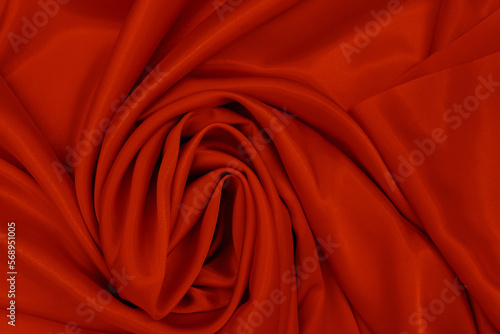 Abstract silk red background. Luxurious smooth elegant wavy fabric. Can be used as Valentine's Day background or other design. Top View, Copy Space