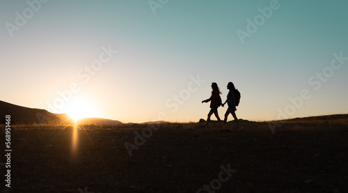two people walk along a mountain range © zhukovvvlad