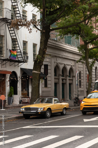 Retro car on urban street near buildings in New York City.