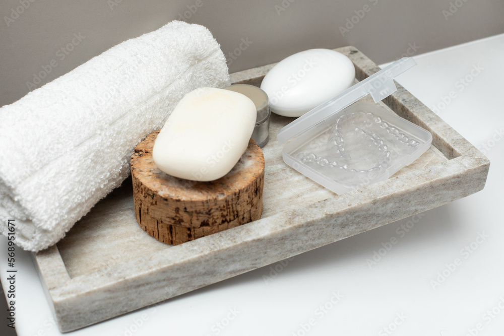 Soap, creme, towel and case with transparent aligner on table Soap, creme, towel and case with transparent aligner on table