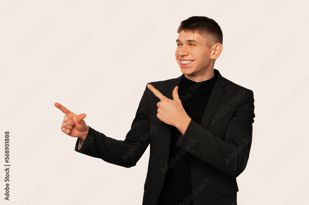 Cheerful young man is pointing aside at white copy space with both hands. Cheerful young man is pointing aside at white copy space with both hands.