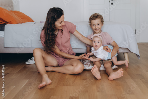 Mother and children on floor near bed