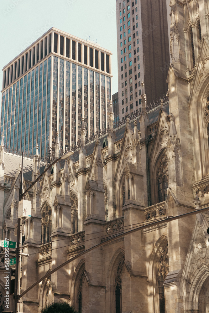 Naklejka premium Facade of St. Patrick's Cathedral with lights on street in New York City.