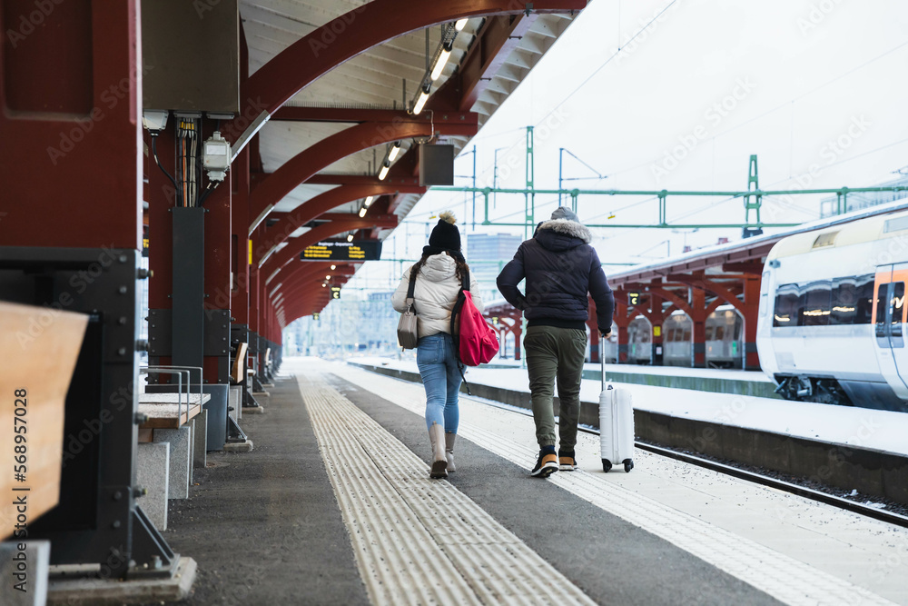 custom made wallpaper toronto digitalCouple walking with suitcase in a train station