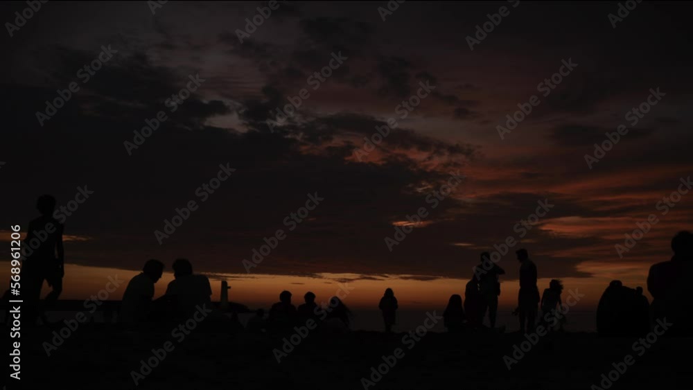 Time lapse of silhouettes of a crowd at sunset on the beach fade out. Time lapse of silhouettes of a crowd at sunset on the beach fade out.