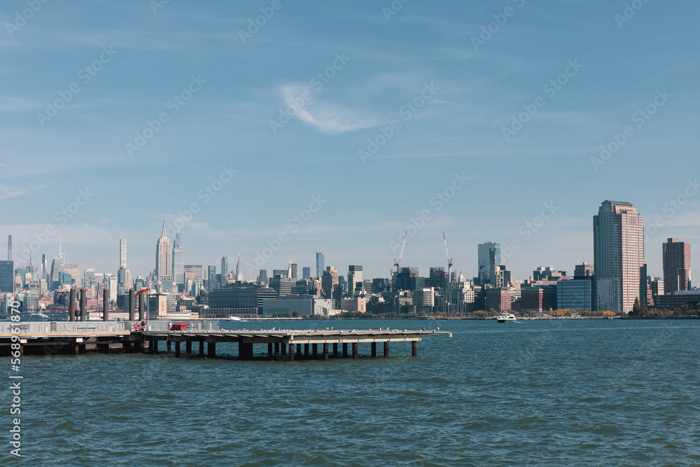 picturesque view of New York bay with pier and skyscrapers of Manhattan.