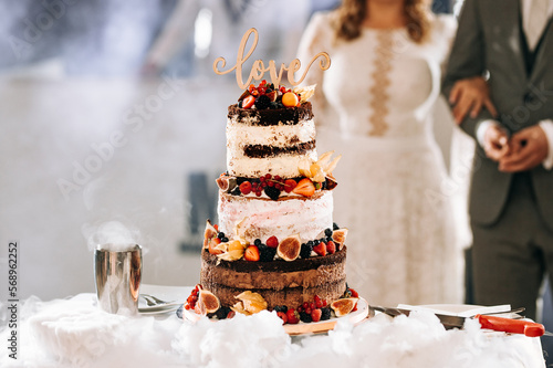 Wedding cake love bride and groom are cutting with knife the torte together couple in restaurant luxury party sweet table delicious gâteau fruits flowers chocolate married party marriage happiness