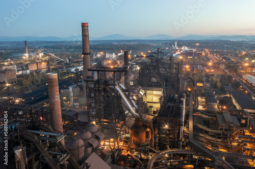 Smelter with blast furnaces from above during evening. Heavy industry plant with lights.
