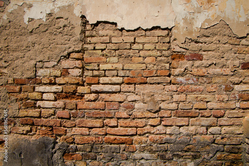 Old brick wall with crumbling plaster, grunge background