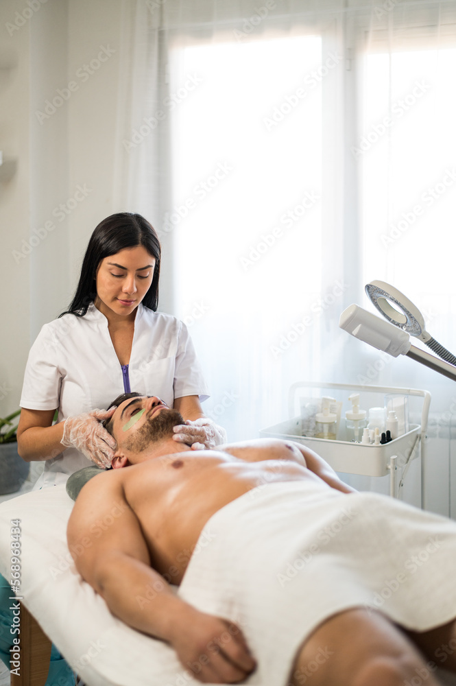 Female cosmetologist applying patches to client Female cosmetologist applying patches to client