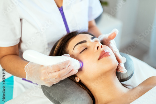 Calm lady getting ultraphonophoresis and pimple reduction in clinic photo