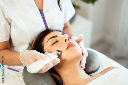 Cosmetologist giving facial cleaning to client photo