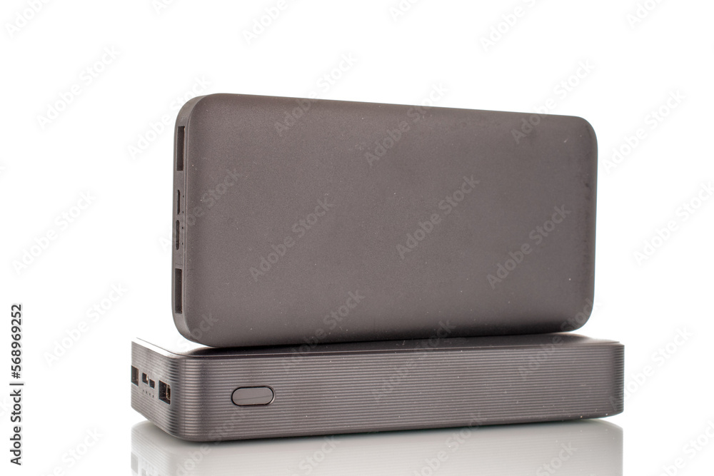 Two black portable power bank chargers with red paper box, close-up isolated on white background. Two black portable power bank chargers with red paper box, close-up isolated on white background.