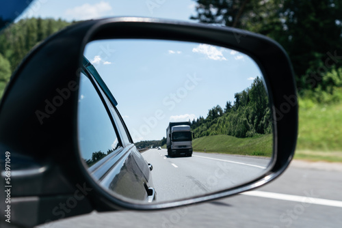 Reflection of the road in the mirror of the car while driving.