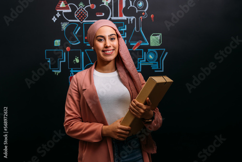 Smiling Muslim worker with folder in modern office photo