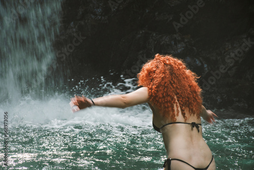 Curly red hair woman on water photo