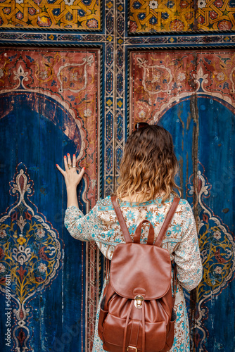 A woman looks at a decorated door in Marrakech photo