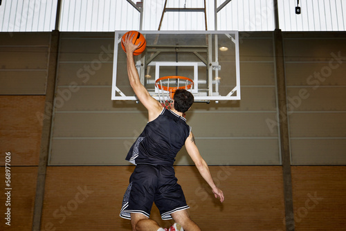 Basketball player throwing ball into hoop photo