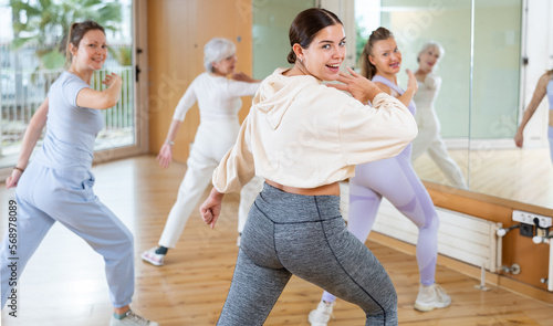 Cheerful energetic female dancers of different ages learning new dancing steps in modern fitness class