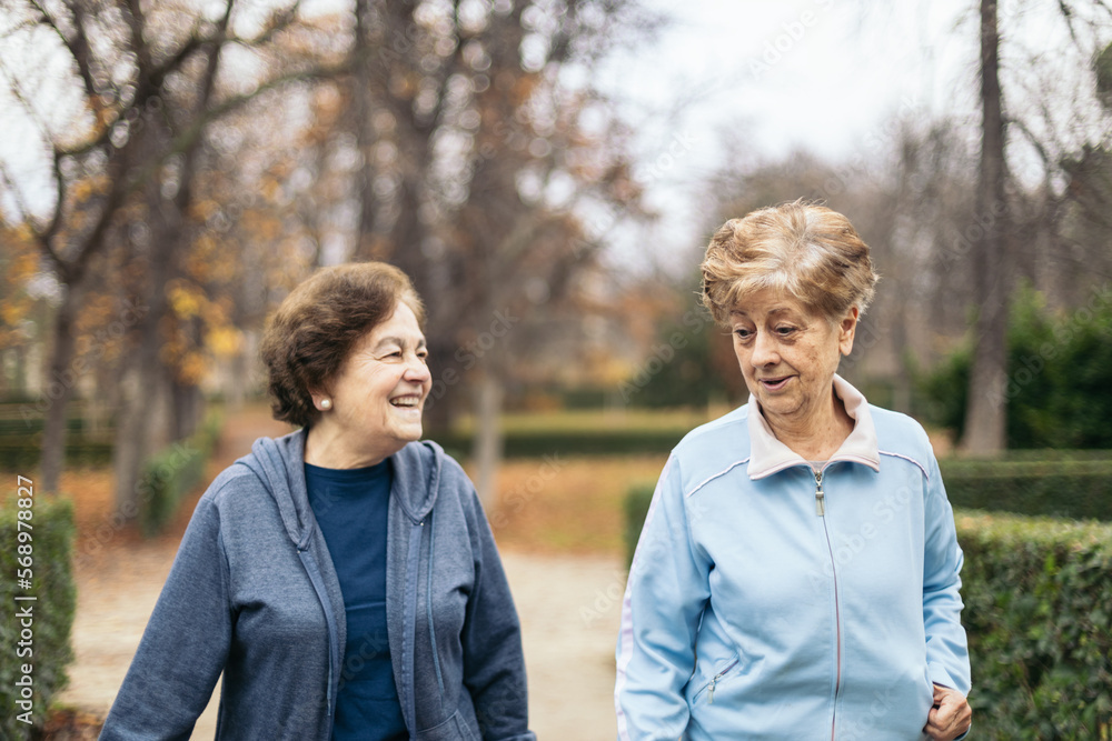 Two senior women in sportswear walking and exercising in a park Two senior women in sportswear walking and exercising in a park