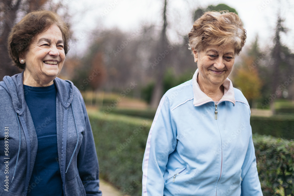 Two elderly women in sportswear walking in the park Two elderly women in sportswear walking in the park