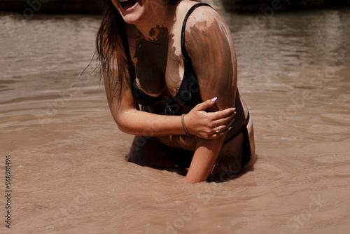 Girl enjoying mud-bathing photo