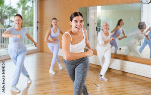 Active young woman practicing aerobic dance in training hall during fitness dance classes. Women training dance in hall