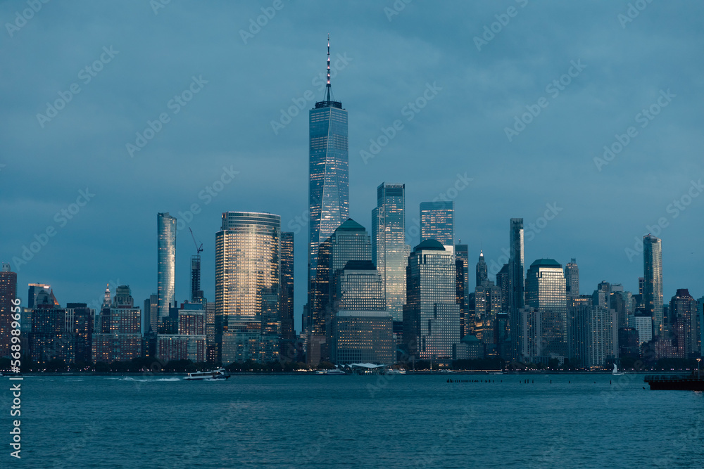 Fototapeta premium scenic view of Hudson river harbor and skyscrapers of Manhattan financial district in dusk.