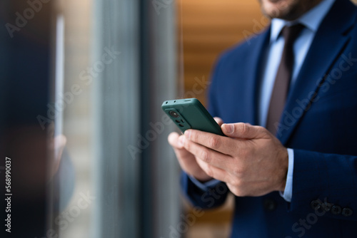 Close up view of businessman using smartphone, focus on phone