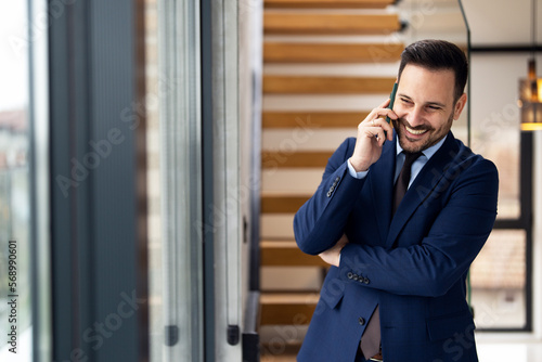 Photos Portrait of handsome businessman using smartphone in modern office