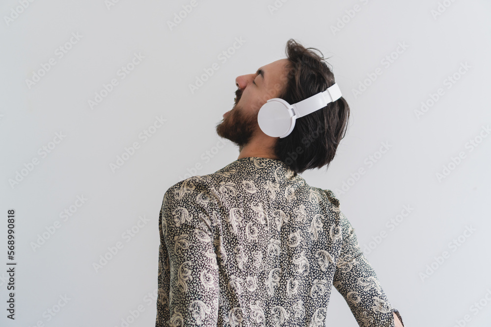 Young queer latin gay man screaming a song he is listening to with his  wireless headphones. Copy space. Stock Photo | Adobe Stock